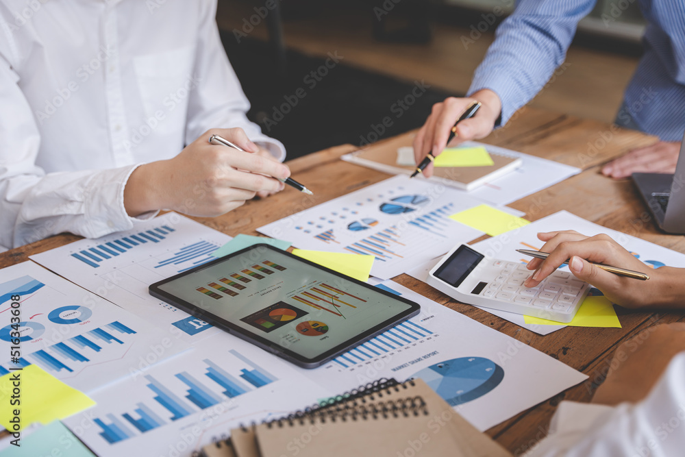 Young colleagues discussing business and price chart analyzes business people on the table great in modern coworking office teamwork concept.