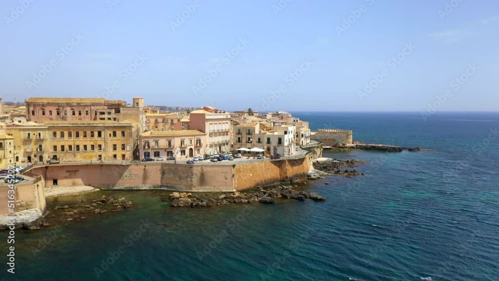Aerial shot of Syracuse coastline with traffic on roads, historic city on the Italian island of Sicily along the Ionian Sea Aerial shot of Syracuse coastline with traffic on roads, historic city on the Italian island of Sicily along the Ionian Sea