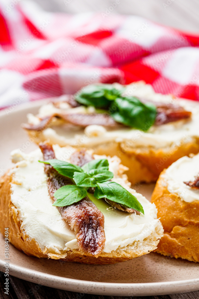 sandwich with anchovy fillet on a tray for serving on a wooden rustic background