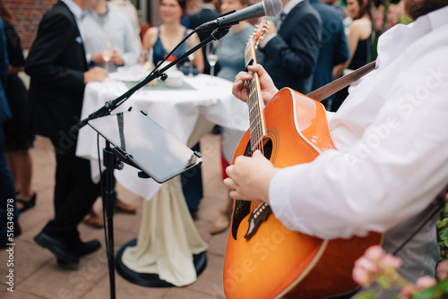 musician playing the guitar. Singer sings on the guitar outside at a wedding. Wedding with live music. Music for private events