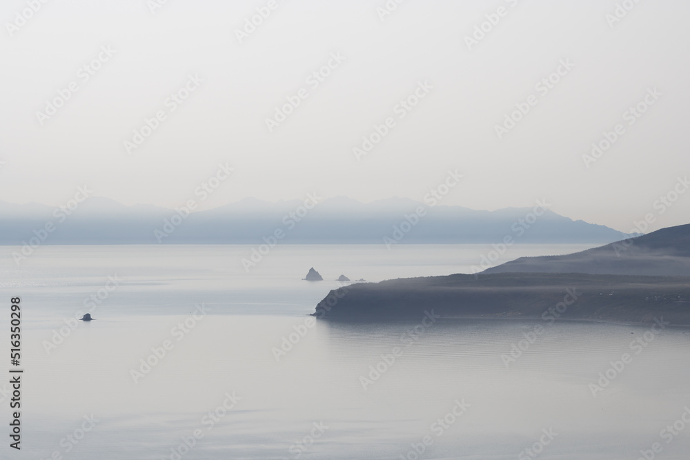 Foggy seascape. View of the cape and rocks in the sea. Gertner Bay, Sea of Okhotsk, Magadan Region, Russian Far East.