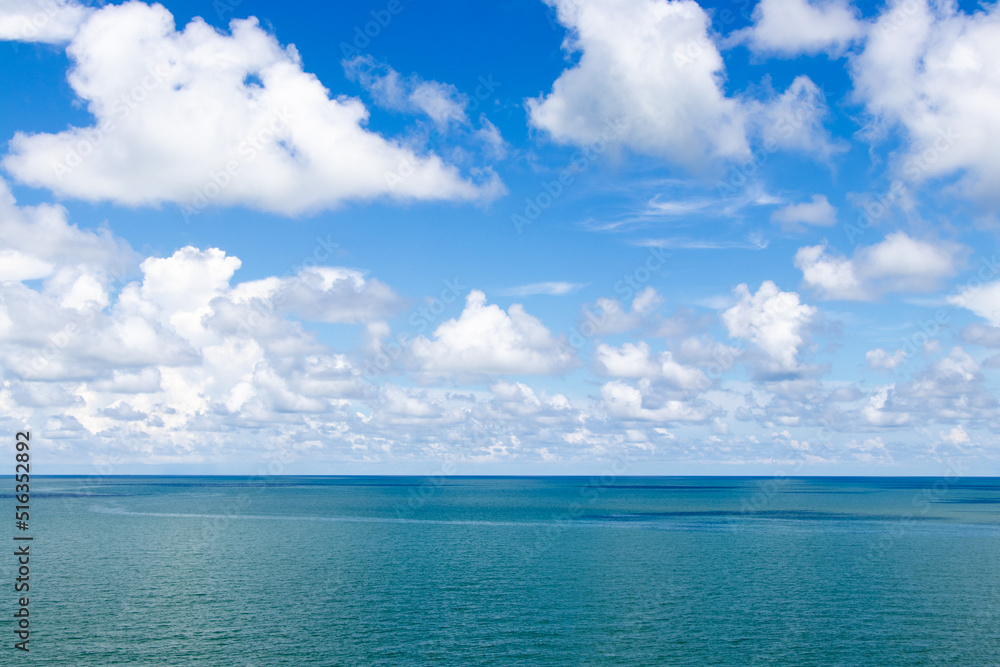 Fototapeta premium Beautiful calm turquoise color sea and blue sky with white color cloud background