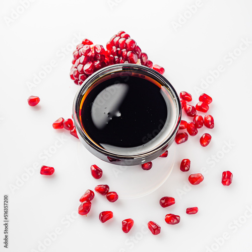 fresh pomegranate sauce narsharab on a white acrylic background photo