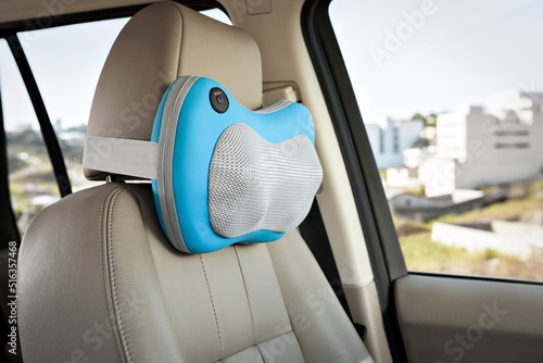 Blue and gray electric neck massager for car, on a car seat