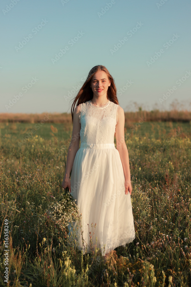 Romantic woman dancing in a wonderful flower field. Warm sunset colors Romantic woman dancing in a wonderful flower field. Warm sunset colors