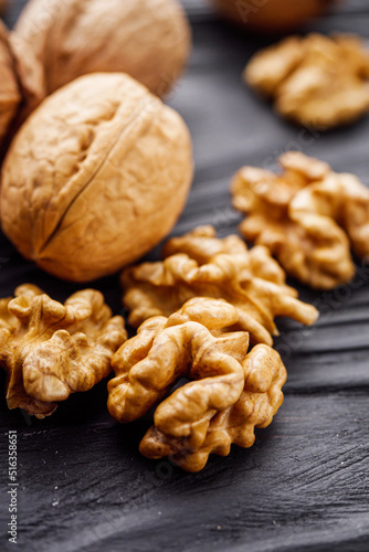 dried walnuts on a black rustic wooden background © Narsil