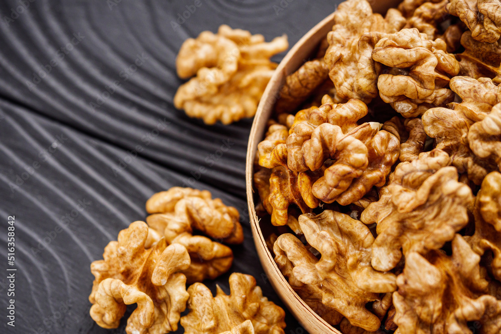 dried walnuts on a black rustic wooden background dried walnuts on a black rustic wooden background