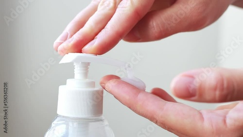 Woman push dispenser and antibacterial liquid soap or antiseptic squeezed out to hand, closeup on white room background. Washing hands at bathroom, using soft gel for advanced skin care.