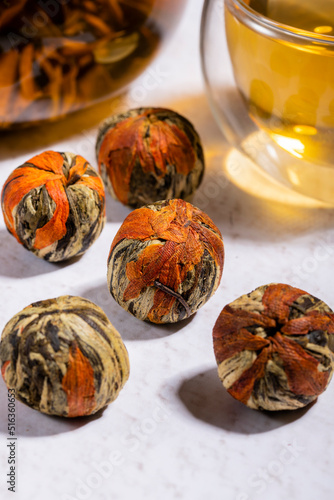 Pressed Green Chinese Oolong Tea Balls blooms in a teapot in the form of a flower photo