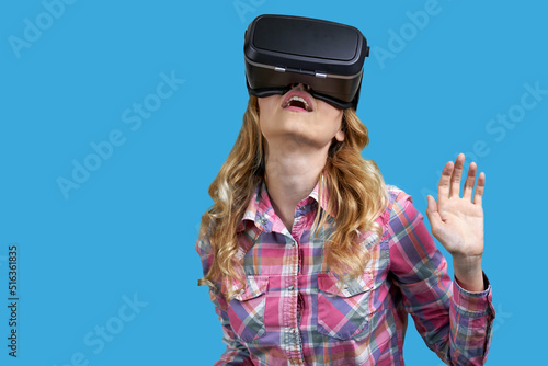 Young woman wearing virtual reality headset on color background. Immersion in the virtual world.