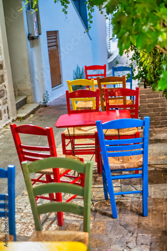 Colourful wooden chairs outside an island restaurant in summer, holiday concept