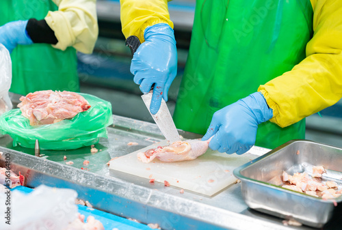 Worker cut up chicken part remove bone out for special product