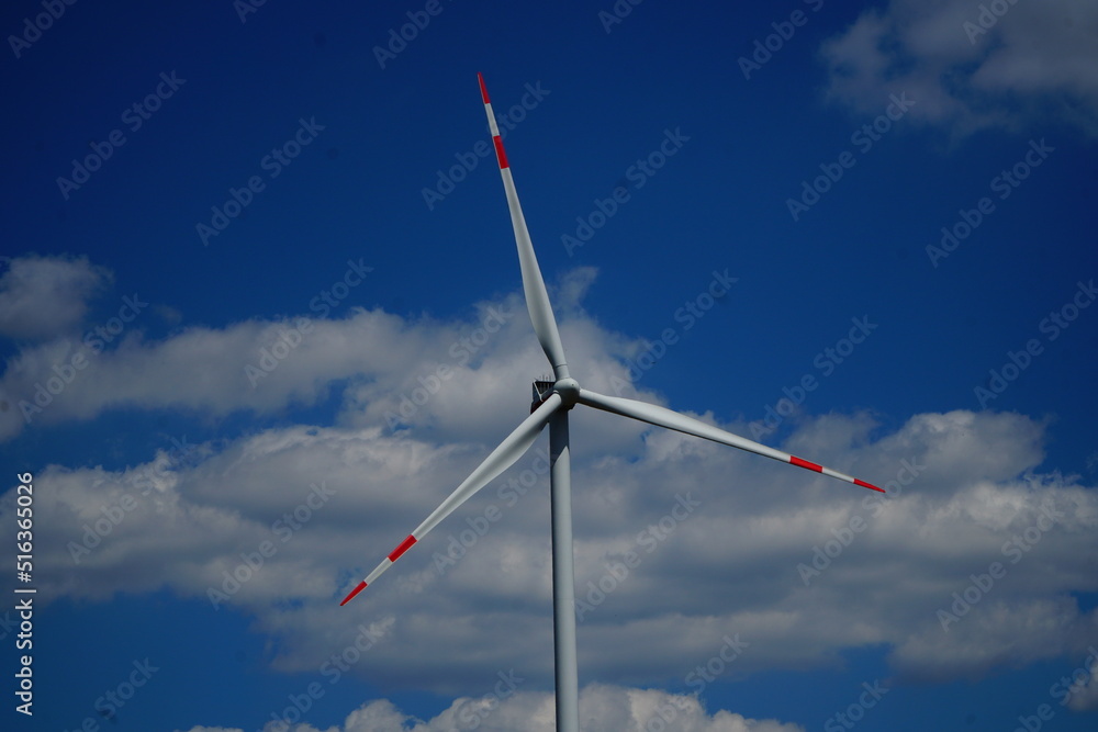 Windmill blades with red lines against a blue sky with clouds close-up Windmill blades with red lines against a blue sky with clouds close-up