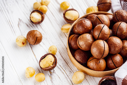 fresh macadamia nuts on a white wooden rustic background