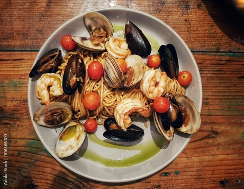 Top view of seafood pasta with cherry tomatoes on a plate in a restaurant in Quintana Roo, Mexico photo