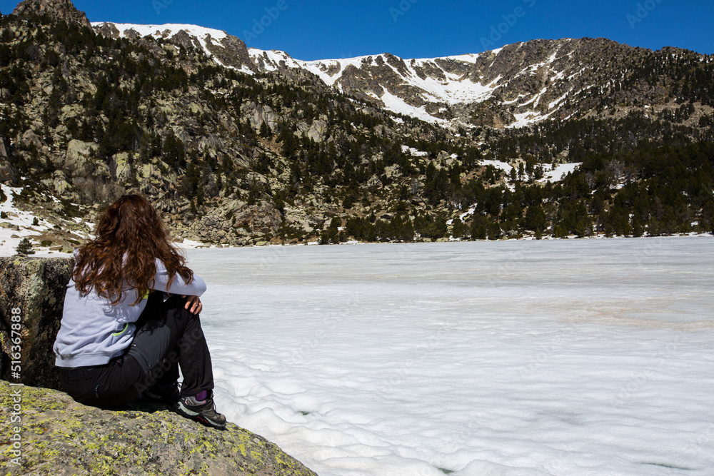 Young hiker girl enjoying in Malniu lake, Cerdanya, Pyrenees, Spain