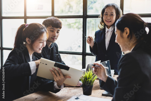 Business meeting. The senior manager talks to employees in the conference room and discuss company project development strategies during the meeting.