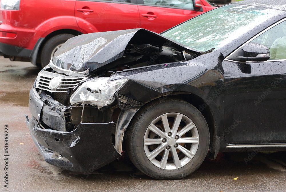 A smashed black car after an accident A smashed black car after an accident