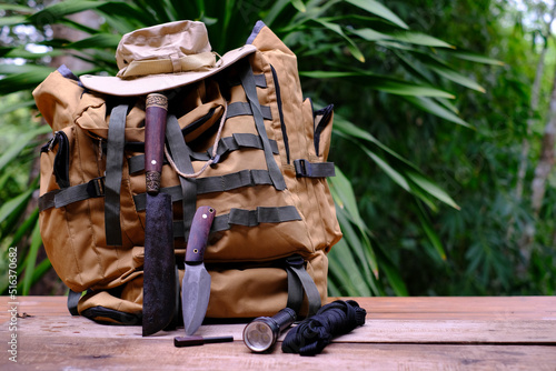 A knife with equipment for survival in the jungle on an old wooden floor