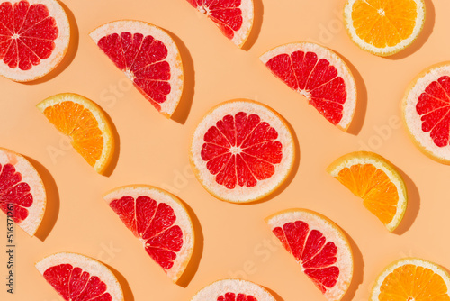 Citrus fruits slices with harsh shadows background. Grapefruit and orange slices, vitamin, summer minimal background