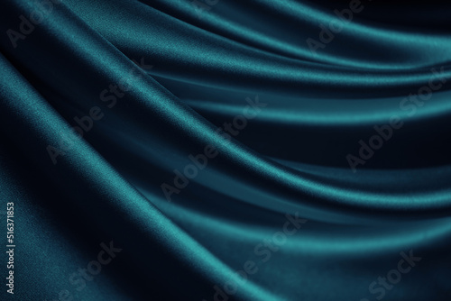 Blue green silk satin. Soft wavy folds. Shiny silky fabric. Dark teal color elegant background with space for design. Curtain. Drapery. Christmas, valentine, anniversary, celebration concept.