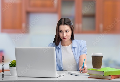 Happy young woman student learning at home looking at laptop computer watching online webinar, having virtual work meeting