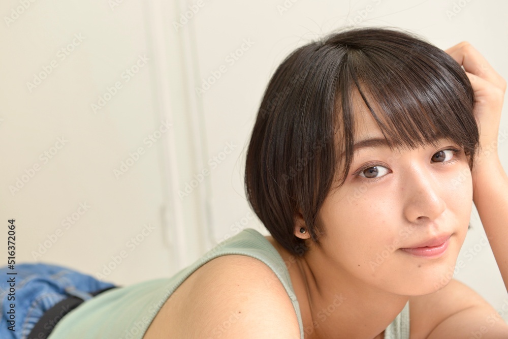 室内にてくつろぐキャミソール姿の若い女性のポートレート 室内にてくつろぐキャミソール姿の若い女性のポートレート