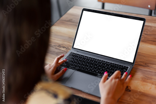 Close up of woman hands typing on laptop in cafe