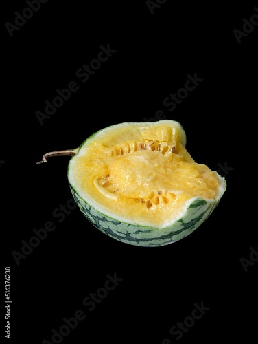 Closeup shot of a Watermelon (Citrullus lanatus) yellow inside isolated on black background photo