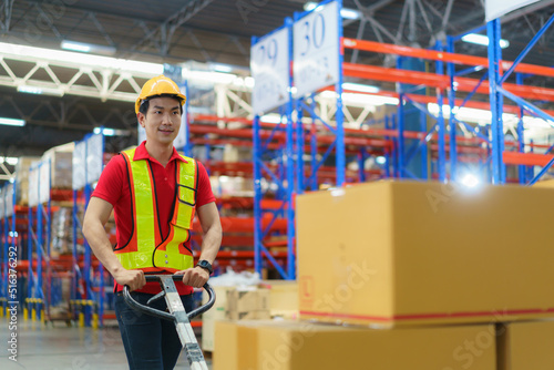 Shipping boxes. Asian man Warehouse worker unloading pallet shipment goods into a truck container, warehouse industry freight, logistics and transport.