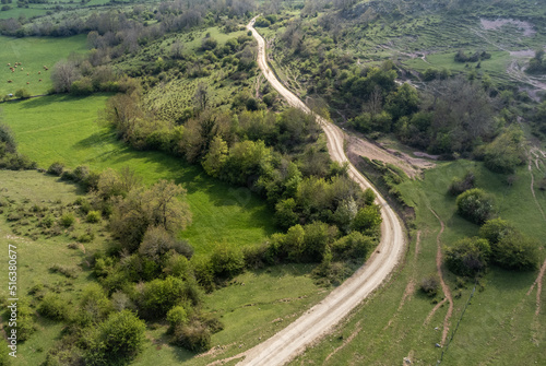 Vista de dron de un paisaje verde con sendero de media montaña en primavera