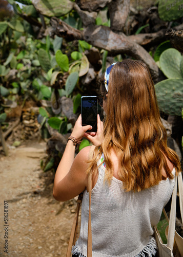 Foto scattata ad una ragazza che sta fotografando dei cactus lungo il sentiero che collega Porto Azzurro con la vicina spiaggia di Barbarossa. photo