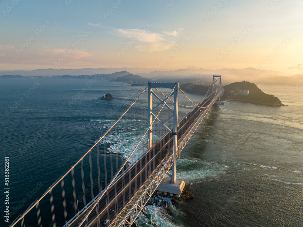 Overhead view of span with light traffic on suspension bridge at sunset