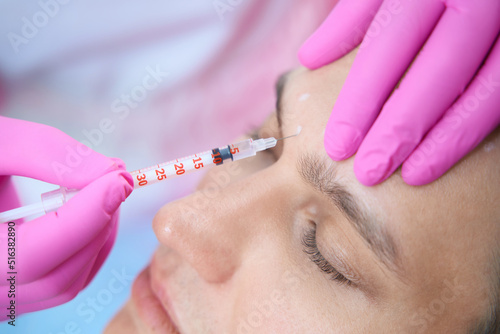 Calm man doing antiage injections in beauty salon