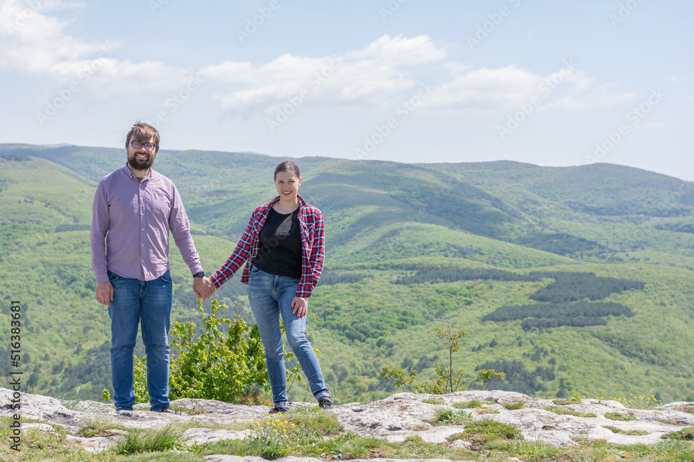 Love couple Man and Woman stand holding hands. Concept: outdoor recreation hiking alleys in the mountains tourists travelers active recreation 