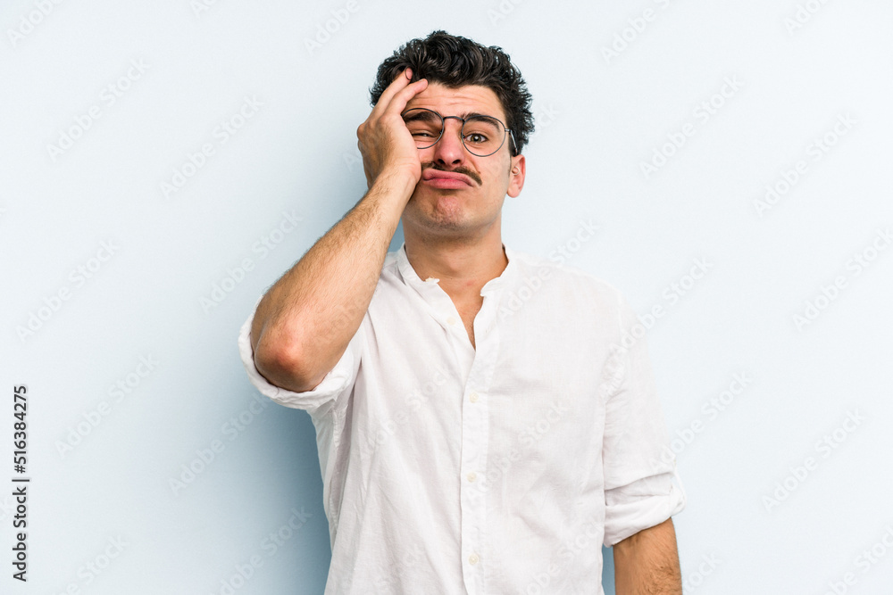 Young caucasian man isolated on blue background tired and very sleepy keeping hand on head. Young caucasian man isolated on blue background tired and very sleepy keeping hand on head.