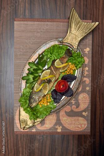 Fotografia well-done trout on a bronze copper dish