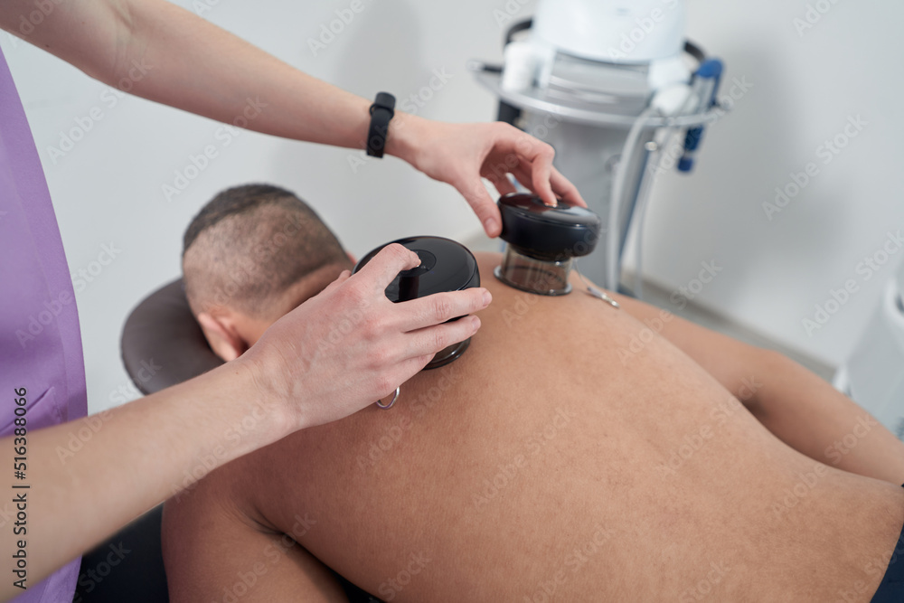 Man receiving vacuum therapy treatment in rehabilitation clinic Man receiving vacuum therapy treatment in rehabilitation clinic