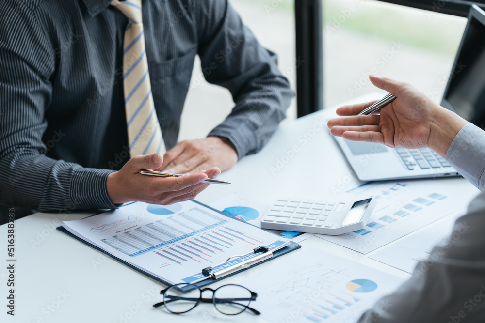 Group of business people meeting, discussing, analyzing graphs, financial data, and planning a marketing project together Group of business people meeting, discussing, analyzing graphs, financial data, and planning a marketing project together