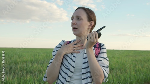 4K. A young woman speaks into a walkie-talkie in the field