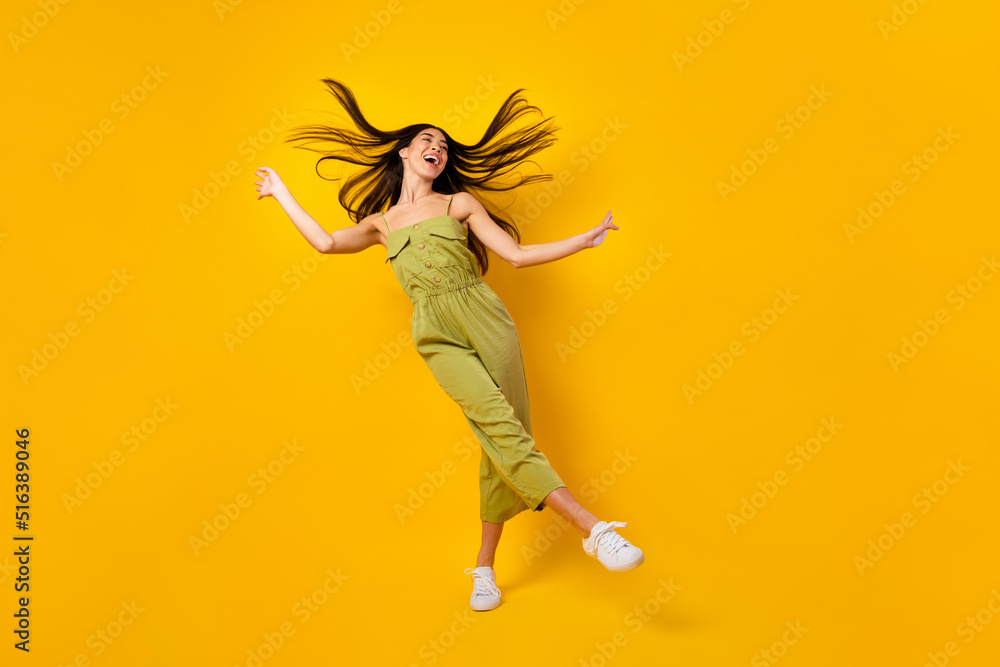 Full length photo of adorable pretty thai person dancing clubbing isolated on yellow color background Full length photo of adorable pretty thai person dancing clubbing isolated on yellow color background