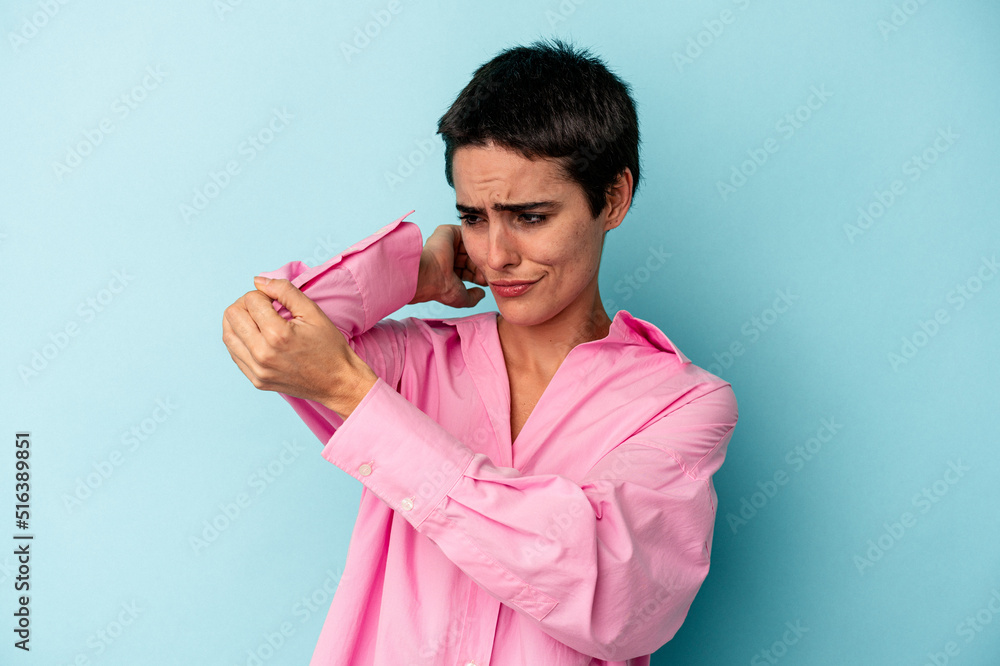 Young caucasian woman isolated on blue background having a neck pain due to stress, massaging and touching it with hand. Young caucasian woman isolated on blue background having a neck pain due to stress, massaging and touching it with hand.