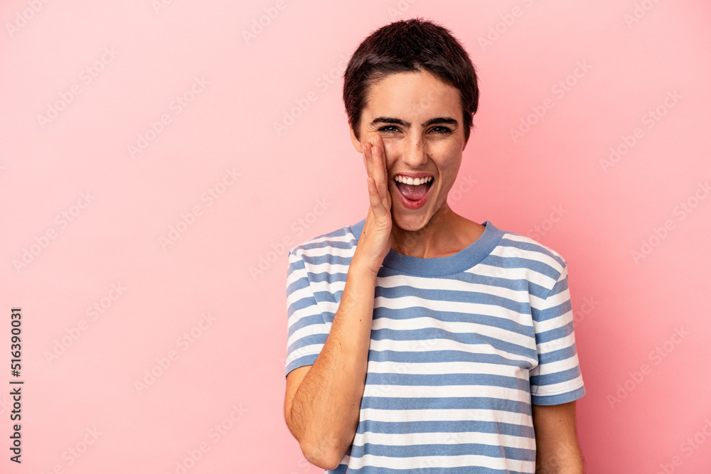Young caucasian woman isolated on blue background shouts loud, keeps eyes opened and hands tense. Young caucasian woman isolated on blue background shouts loud, keeps eyes opened and hands tense.