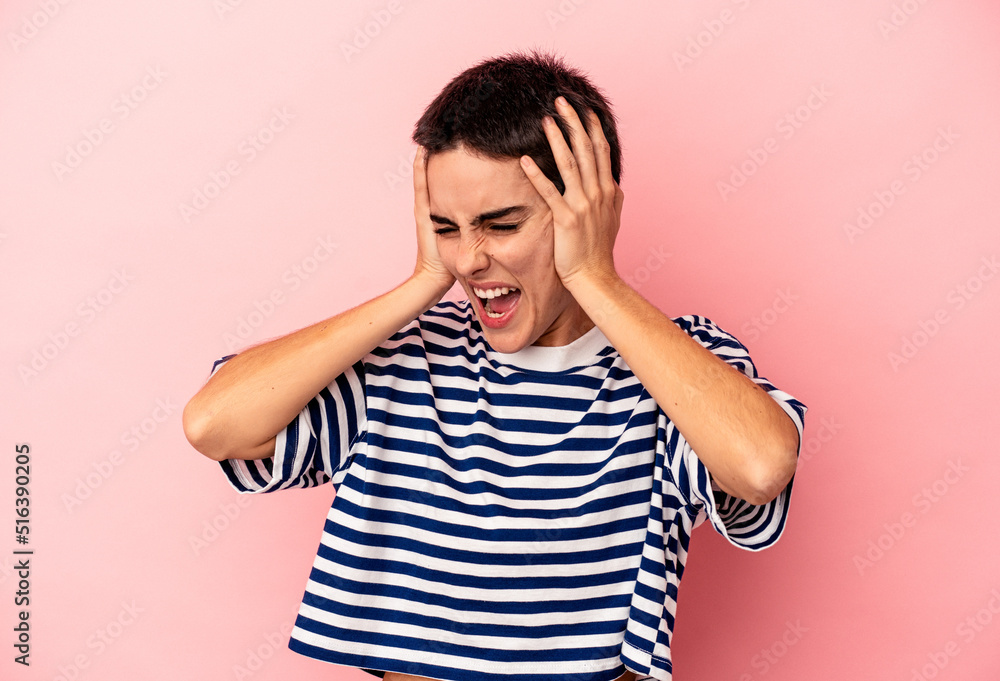 Young caucasian woman isolated on blue background covering ears with hands trying not to hear too loud sound. Young caucasian woman isolated on blue background covering ears with hands trying not to hear too loud sound.