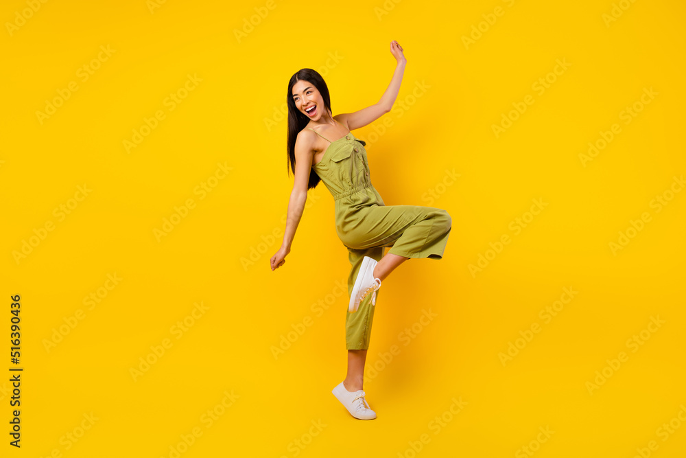 Full size photo of lovely overjoyed filipino lady chilling dancing spend pastime isolated on yellow color background Full size photo of lovely overjoyed filipino lady chilling dancing spend pastime isolated on yellow color background
