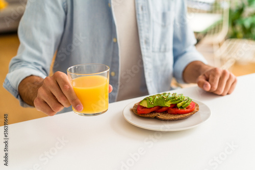 Young mixed race man having breakfast in his kitchen