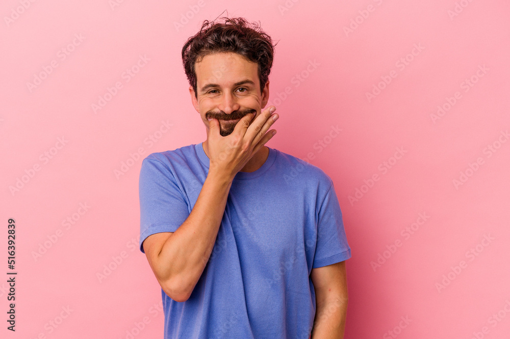 Young caucasian man isolated on pink background doubting between two options. Young caucasian man isolated on pink background doubting between two options.