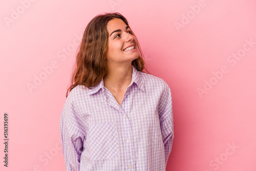Young caucasian woman isolated on pink background  relaxed and happy laughing, neck stretched showing teeth. © Asier