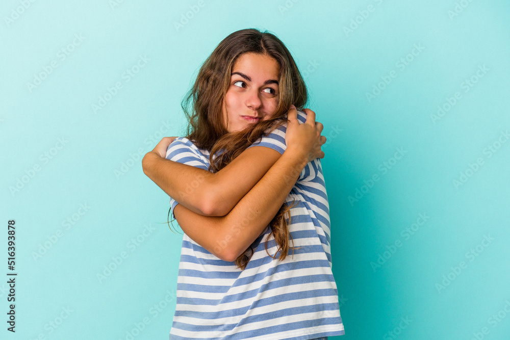 Young caucasian woman isolated on blue background hugs, smiling carefree and happy. Young caucasian woman isolated on blue background hugs, smiling carefree and happy.