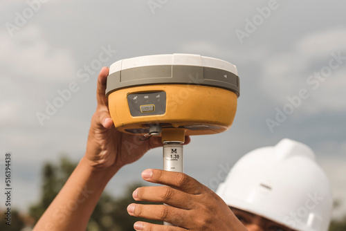 An engineer sets up a Global Navigation Satellite System or GNSS Receiver. Real-time kinematic or RTK geodetic surveying equipment used in the field.